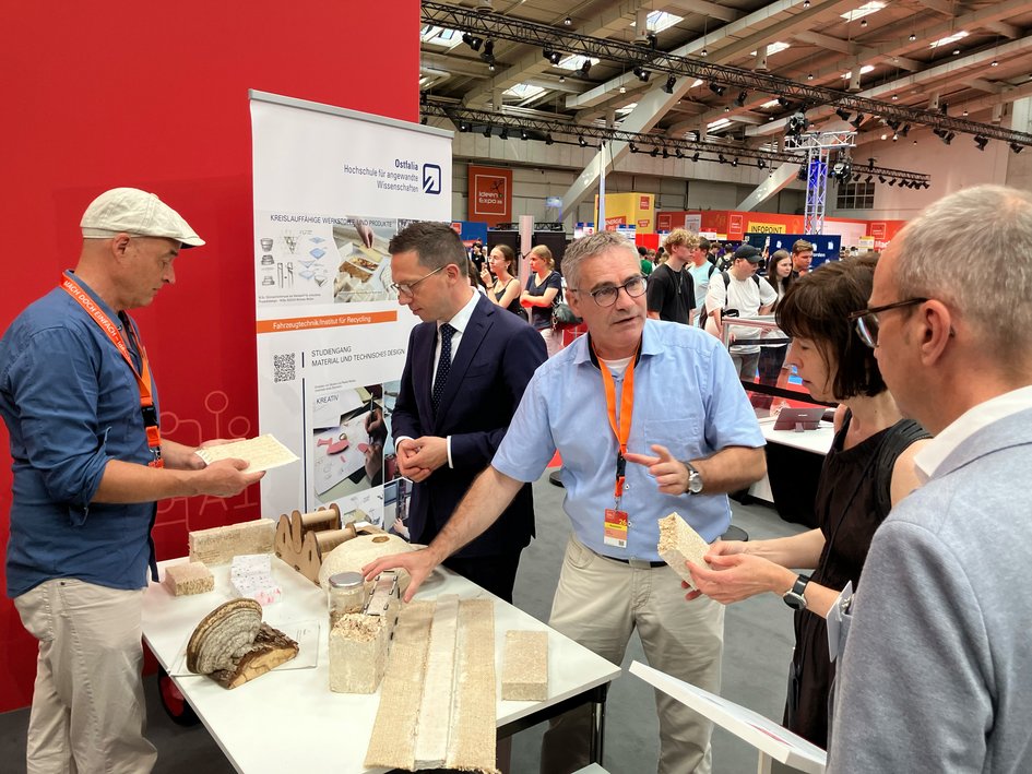 Die Ostfalia auf der IdeenExpo in Hannover: Prof. Dr. Ingo Johannsen (links) und Prof. Dr. Max Ehleben (rechts) erläutern Wissenschaftsminister Falko Mohrs (zweiter von links) die Forschung der Hochschule im Bereich zirkulärer Rohstoffe und Pilz-Myzel.