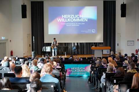 Rahmenprogramm auf der Bühne: Ostfalia-Absolvent und Berufsmusiker Robin Kap spielt bei der Erstsemesterbegrüßung im Audimax am Campus Wolfenbüttel. (öffnet Vergrößerung des Bildes)