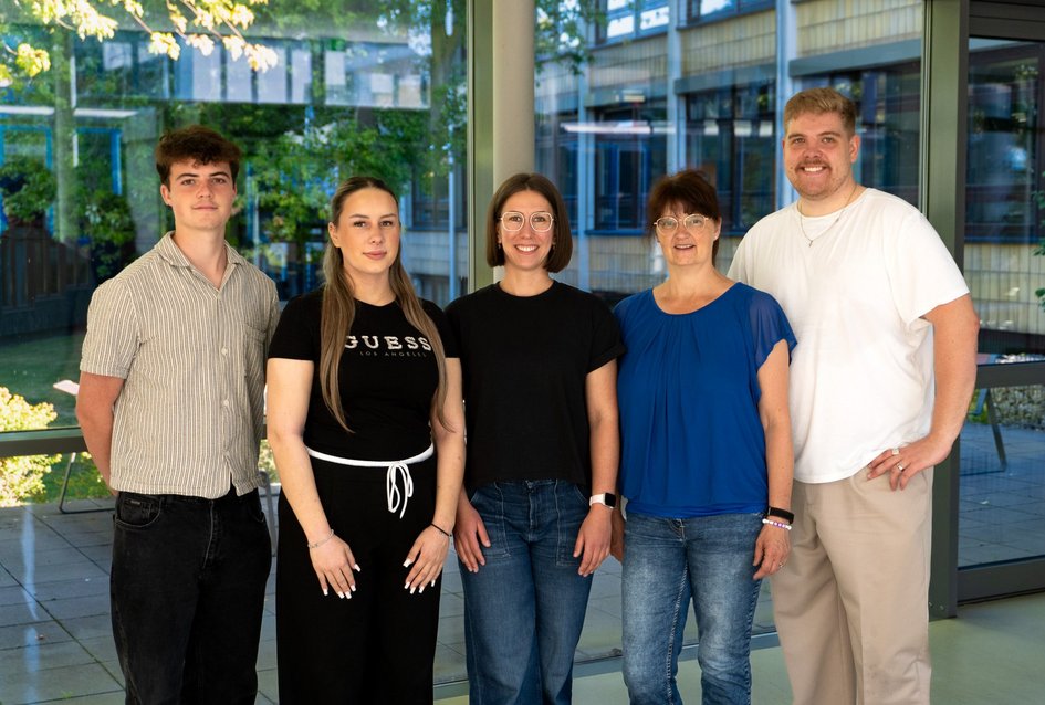 Vier Mitarbeitende des Hochschulsports und des Gesundheitsmanagement lächeln in die Kamera, um zu signalisieren, wer Ansprechperson im Bereich ist