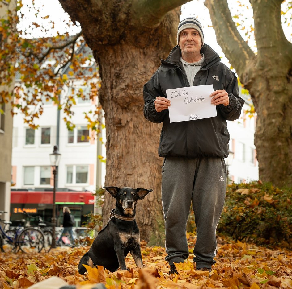 Die Menschen halten auf den Fotos ihre Weihnachtswünsche in die Kamera.