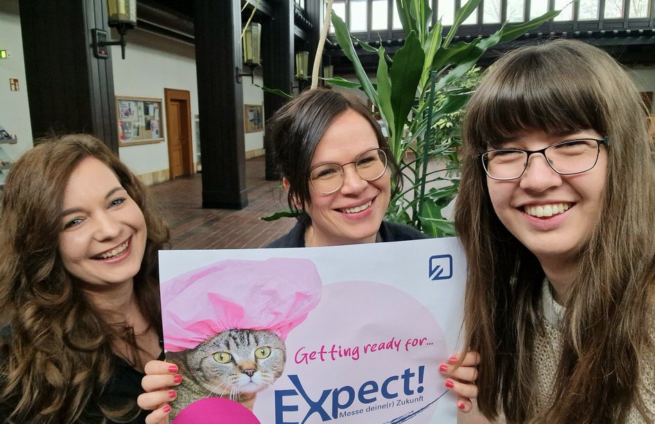 Bild vom Messeteam - drei Frauen lächeln in die Kamera.