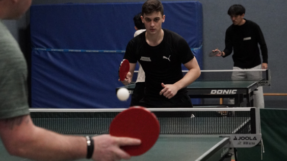 Two young men playing table tennis