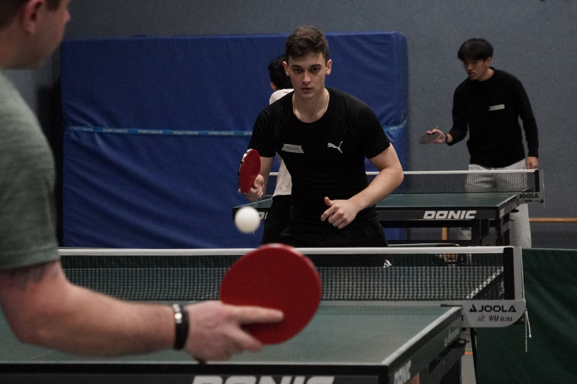 Two young men playing table tennis