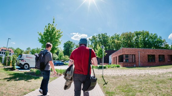 Studierende auf dem Weg zum Gebäude des INBW am Campus Suderburg.