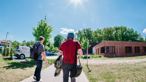 Studierende auf dem Weg zum Gebäude des INBW am Campus Suderburg.