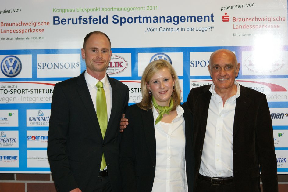 Die OK-Leitung und Martin Kind stehen gemeinsam vor der Sponsorenwand