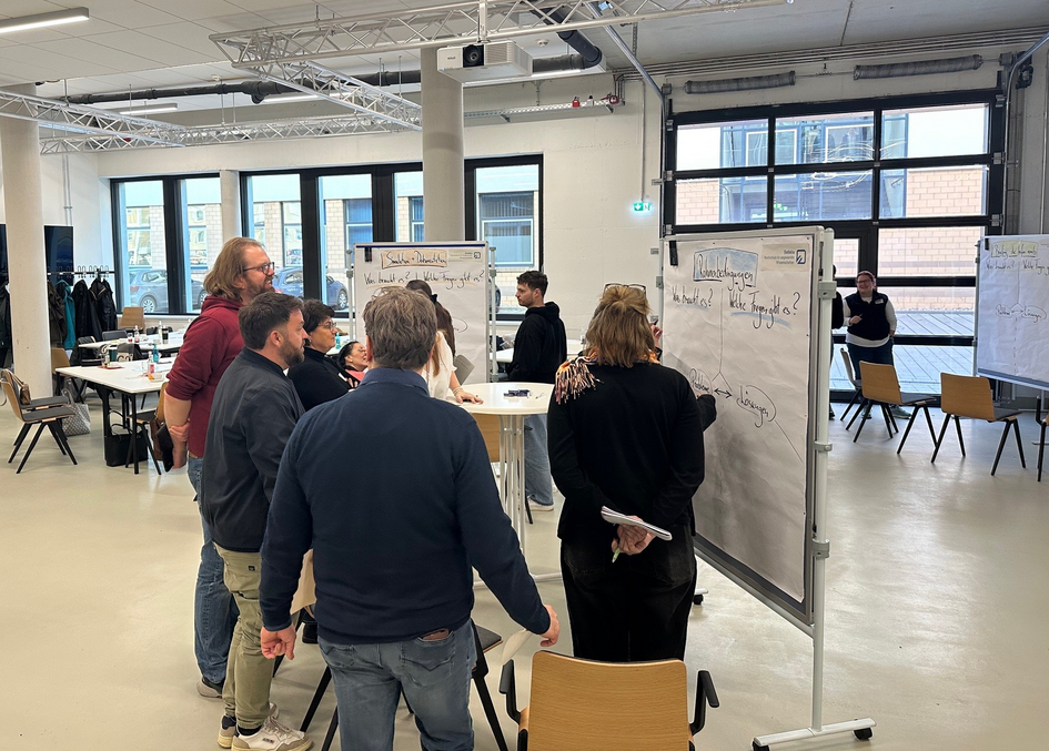 Teilnehmende der Weiterbildung bei der Gruppenarbeit an Pinnwänden