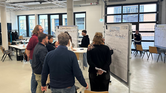 Teilnehmende der Weiterbildung bei der Gruppenarbeit an Pinnwänden
