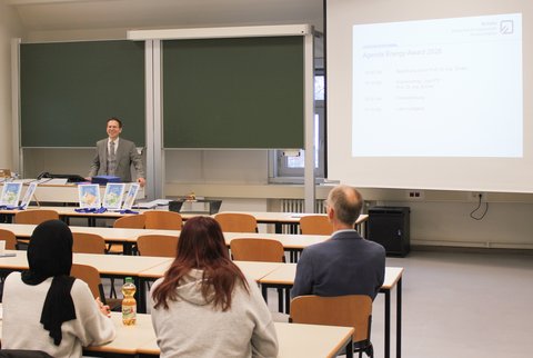 Prof. Dr. Henning Zindler bei der Preisverleihung präsentiert vor den Schüler*innen. (öffnet Vergrößerung des Bildes)
