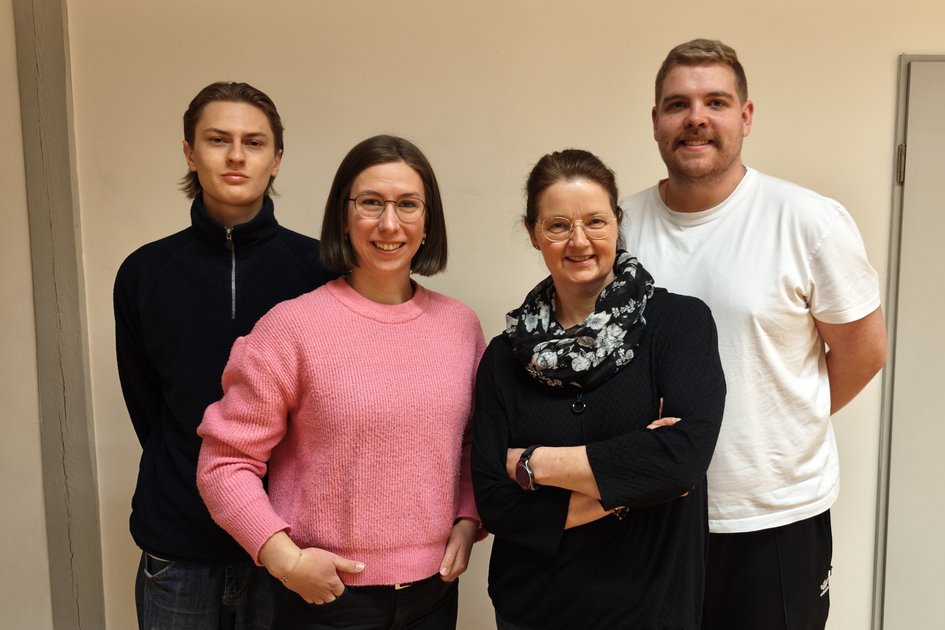 Vier Mitarbeitende des Hochschulsports und des Gesundheitsmanagement lächeln in die Kamera, um zu signalisieren, wer Ansprechperson im Bereich ist