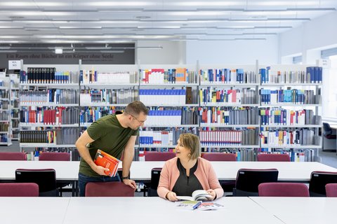 zwei Studierende in der Bibliothek