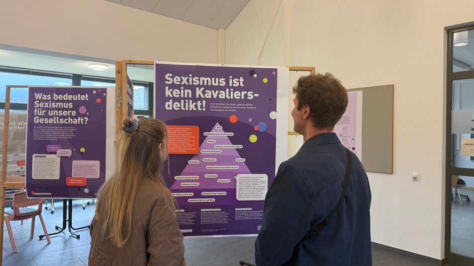 Teilnehmende informierten sich auf Plakaten zum Thema Sexismus