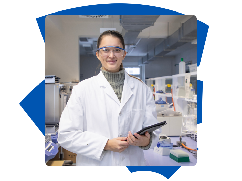 Studentin Miriam der Fakultät Versorgungstechnik im Labor mit zwei Laborutensilien und schaut in die Kamera.