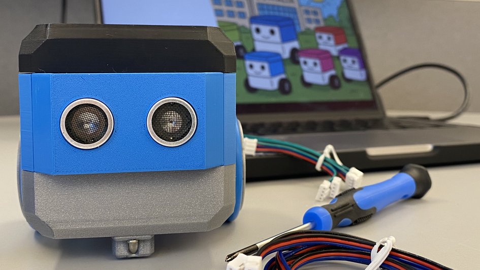 Das Bild zeigt einen kleinen Roboter mit Laptop und Werkzeug. (öffnet Vergrößerung des Bildes)