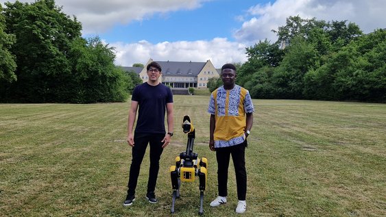 Die Stipendiaten Guy Kamga und Matheus Pereira mit Roboter "Spot".