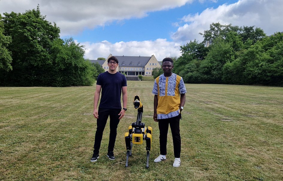 Die Stipendiaten Guy Kamga und Matheus Pereira mit Roboter "Spot".