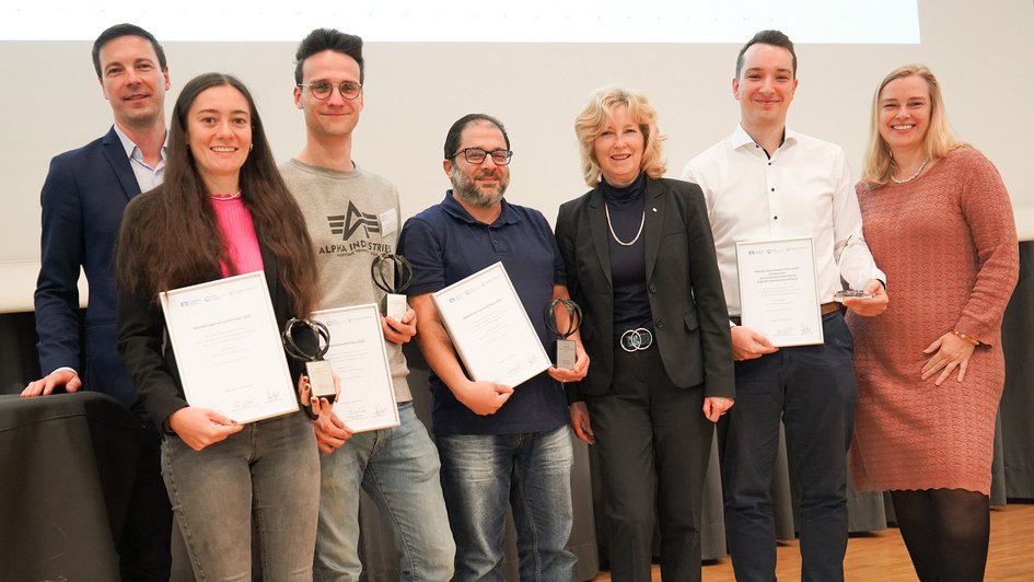 Pressefoto (Nadine Zimmer/Ostfalia): Verleihung des BRAWO-Gemeinwohl-Preises (von links nach rechts) Matthias Marx vom EngagementZentrum, Lena Traichel, Adrian Beichler, Moataz Hawsheh, Claudia Kayser, Leiterin der Direktion Wolfsburg der Volksbank BRAWO, Noah Möller sowie Ostfalia-Präsidentin Julia Siegmüller.