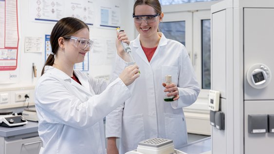 Zwei Studierende arbeiten zusammen in einem Labor. 