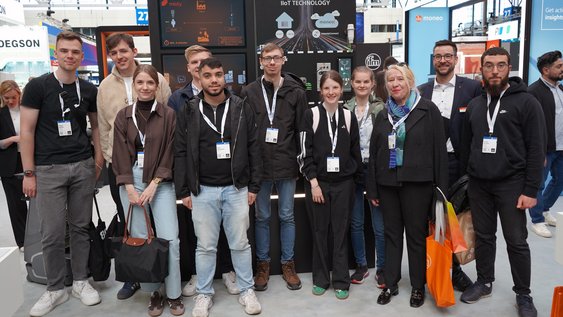 Gruppenfoto der Studierenden mit Regina Müller-Wagner und Pauline Browatzki (beides Wissenschaftliche Mitarbeiterinnen) am Stand eines der Praxispartner im Bereich Logistik. Foto: Marie Ruhm/Ostfalia