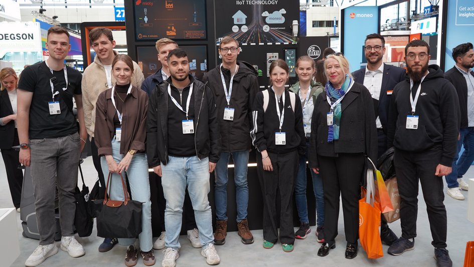 Gruppenfoto der Studierenden mit Regina Müller-Wagner und Pauline Browatzki (beides Wissenschaftliche Mitarbeiterinnen) am Stand eines der Praxispartner im Bereich Logistik. Foto: Marie Ruhm/Ostfalia