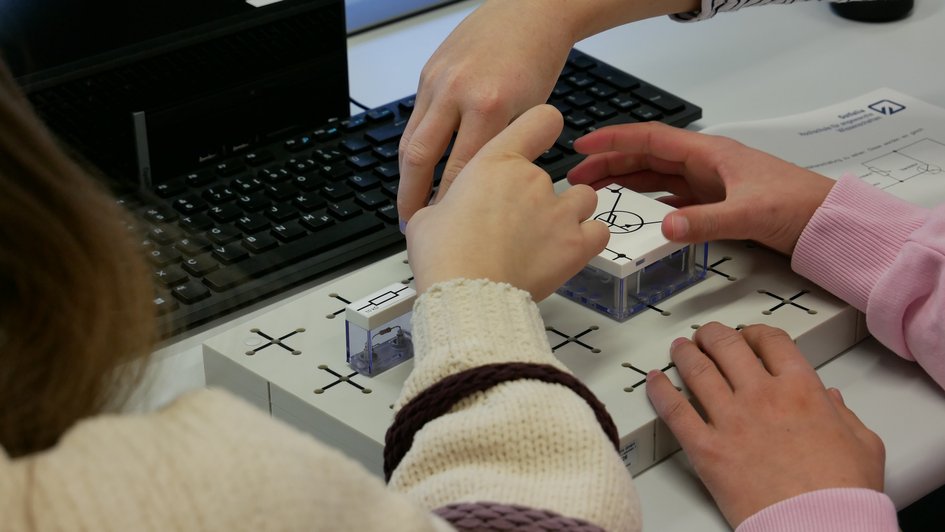 Schülerinnen stecken Schalter zusammen, um einen Audioverstärker zu bauen (öffnet Vergrößerung des Bildes)