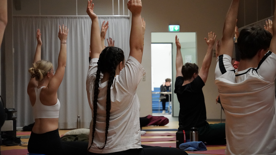 Group of people sitting on the floor doing yoga
