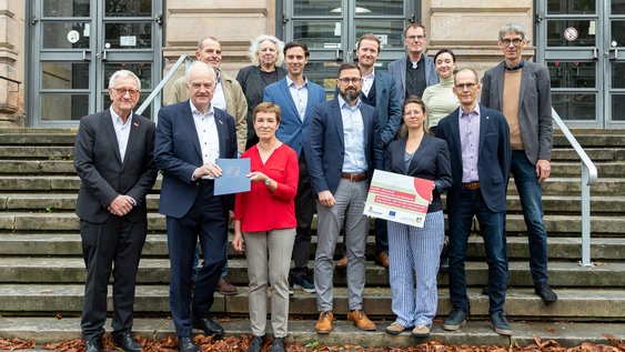 Übergabe des InnoREG-Förderbescheides am 8. Oktober 2025 (vom links nach rechts, erste Reihe zuerst): Jörg Saathoff (Leitung Technologietransfer TU Braunschweig; Prof. Arno Kwade, Vizepräsident für Transfer und Innovation, TU Braunschweig; Astrid Paus, Dezernatsleitung, Amt für regionale Landesentwicklung Braunschweig; Sebastian Hallmann, Referatsleiter, Stadt Braunschweig; Sandra Lindemann, Regionalverband Großraum Braunschweig- Zukunftsregion SON, Björn Hobus, Projektkoordination InnoREG, TU Braunschweig; Kai Hillebrecht, Leitung Wissens- und Technologietransfer, Ostfalia HaW, Nathalie Hauer, Unternehmensservice & Gründung, Wirtschafts- und Innovationsförderung Salzgitter GmbH; Mathis Vetter, Bereichsleiter Innovationsförderung, Braunschweig Zukunft GmbH; Andreas Wiegand, Geschäftsführung, Landkreis Gifhorn Innovation & Service GmbH; Hartmut Keune, Support Antragstellung EU-Projekte, TU Braunschweig, Julia Mehring, Projektkoordinatorin Transfer und Transformation, Ostfalia HaW; Andreas Hebbelmann, Leitung Stabstelle Forschungsservice, TU Braunschweig. 