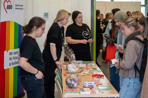 Mitarbeitende eines Trägers im Gespräch mit Studierenden. (öffnet Vergrößerung des Bildes)