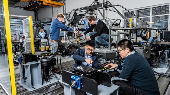 Personen arbeiten an einer Maschine