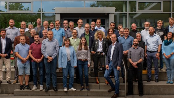 Das Team der Fakultät Maschinenbau steht auf einer Treppe im Außenbereich der Cafeteria