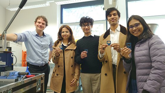 Prof. Dr. Max Jurascheck in a group photo with the DAAD students, who are holding the bottle openers they have made themselves.