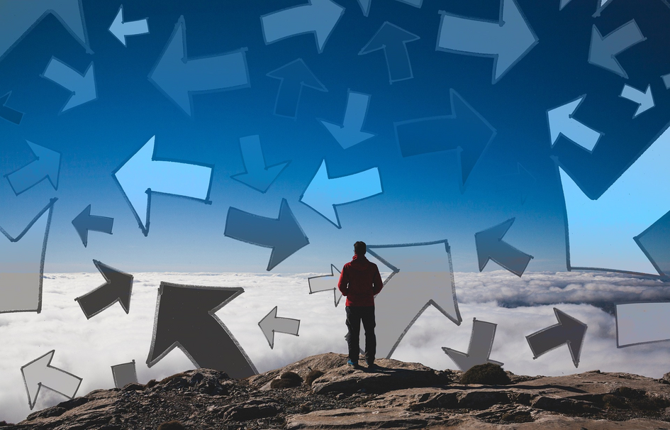 Ein Mann steht auf einem Gipfel und um ihn herum sind viele Pfeile in verschiedene Richtungen