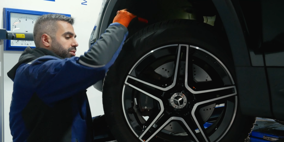 Muhammed Aydin kontrolliert einen Reifen an einem Auto