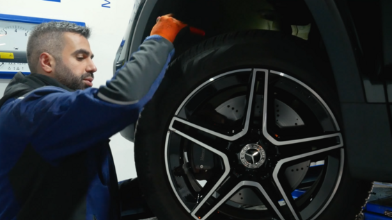Muhammed Aydin kontrolliert einen Reifen an einem Auto