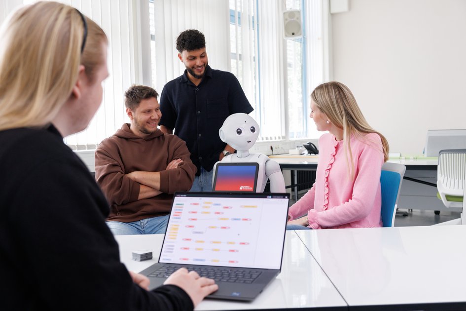 Studierende der Ostfalia Hochschule und ein humanoider Roboter am Campus Suderburg. Dort kann man unter anderem Soziale Arbeit studieren.