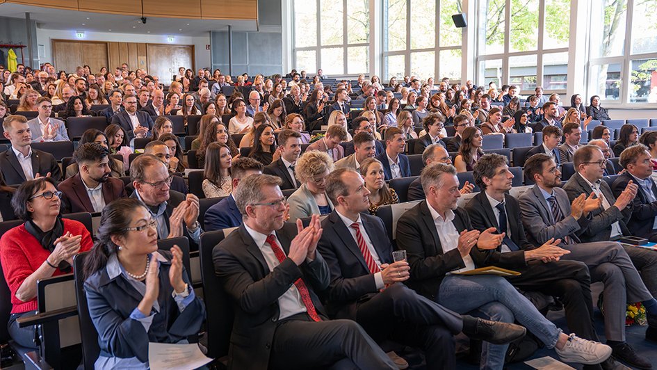 Die Personen im Auditorium der Aula applaudieren während der Abschlussfeier.