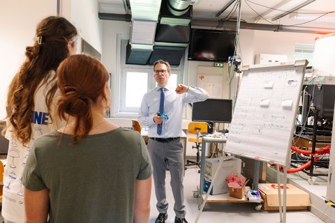 Schülerinnen hören Prof. Dr.-Ing. Zindler bei einem Vortrag im Labor zu.