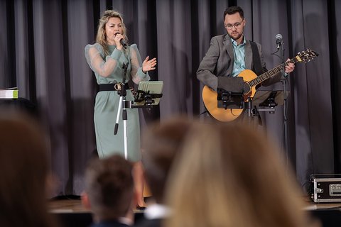 Das Musikduo "Perceived as One" auf der Bühne, im Bildvordergrund unscharf vier Hinterköpfe. (öffnet Vergrößerung des Bildes)