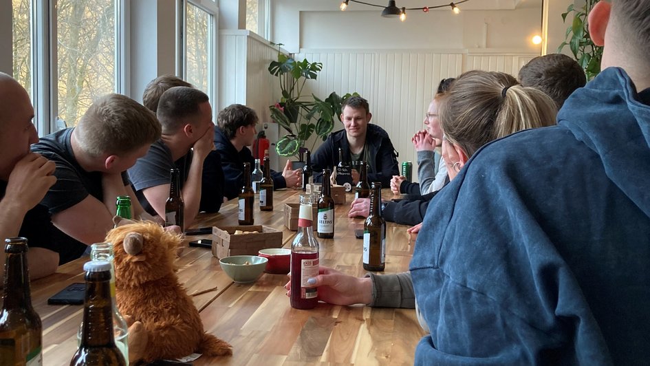 Studierende sitzen gemeinsam am Tisch und unterhalten sich.