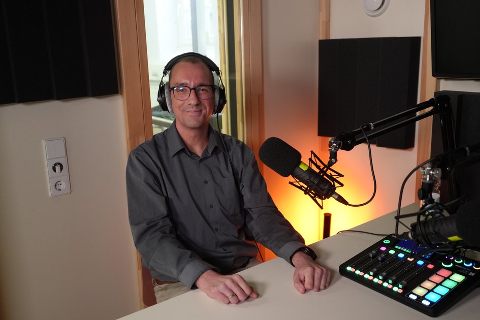 Christoph Rohmann sitzt im Podcast-Studio der Ostfalia Hochschule vor einem Mikrofon. In der Folge des Podcasts „Einfach Forschung“ spricht er mit Prof. Dr. Heinz-Dieter Quack über automatisiertes Fahren und die Mobilität der Zukunft.