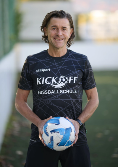 Marco Dehne im Fußballtrikot und mit Fußball in seinen Händen