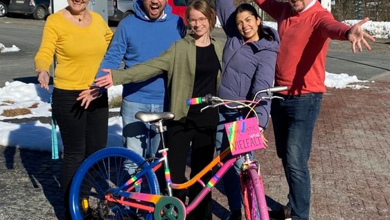 Das Team Radverkehrsmanagement der Ostfalia-Hochschule hinter dem bunt angemalten Vielfalts-Fahrrad mit der Aufschrift „Für Demokratie und Vielfalt“