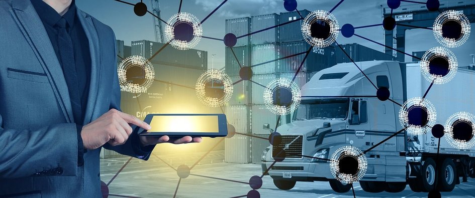 Dekorativ: Person in Anzug bedient Tablet vor LKW und Containern, vernetzte Punkte symbolisieren digitale Steuerung in Logistik und Supply Chain Management