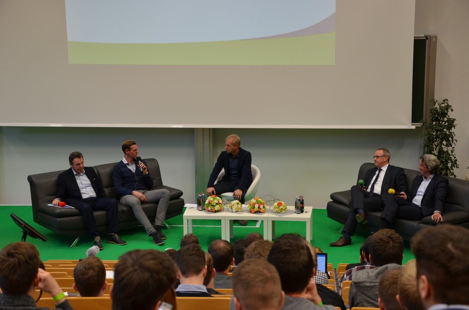 Vier Referenten sitzen mit dem Moderator auf der Bühne.