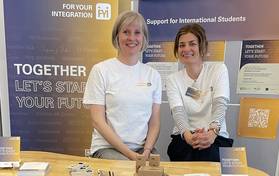 Das Projektteam for your Integration am Info-Stand eines Events.