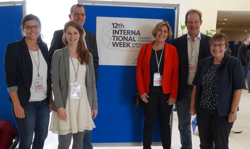 Mitarbeitende der Ostfalia stehen vor einer Plakatwand während der internen International Week
