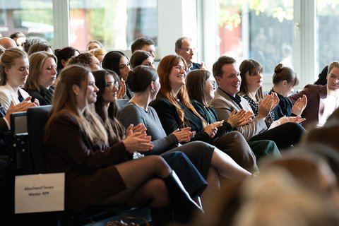 Blick ins Auditorium. Absolventinnen und Absolventen applaudieren. (öffnet Vergrößerung des Bildes)
