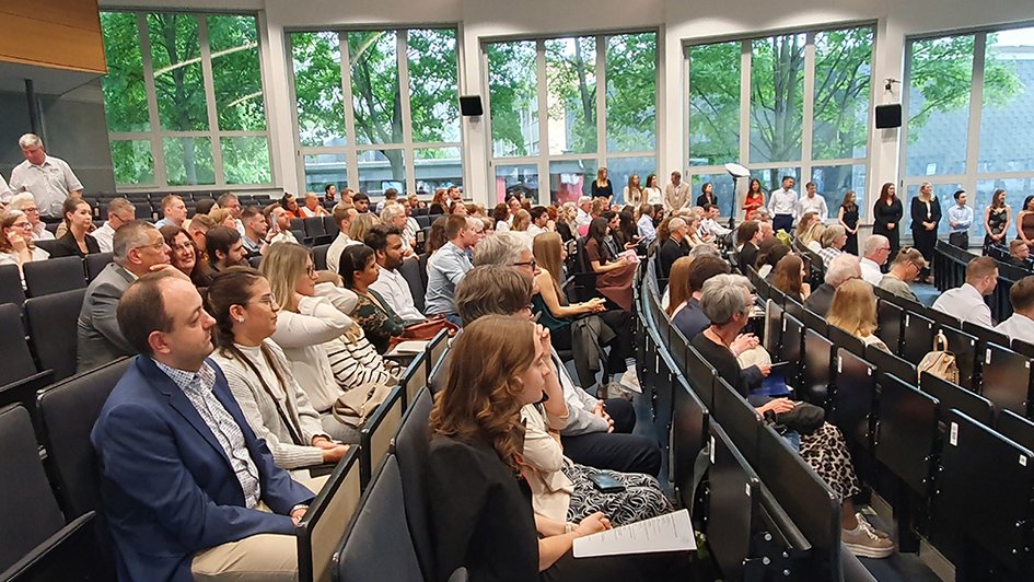 Die Personen im Auditorium der Aula folgen dem Programm der Abschlussfeier.
