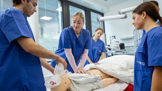 Studierende üben Reanimation an Patietenpuppe
