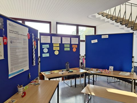 Ein Überblick über den Stand der Fakultät Soziale Arbeit am Standort Wolfenbüttel, welcher Pinnwände mit einem Poster sowie Moderationskarten zur Reflexion zeigt. (öffnet Vergrößerung des Bildes)